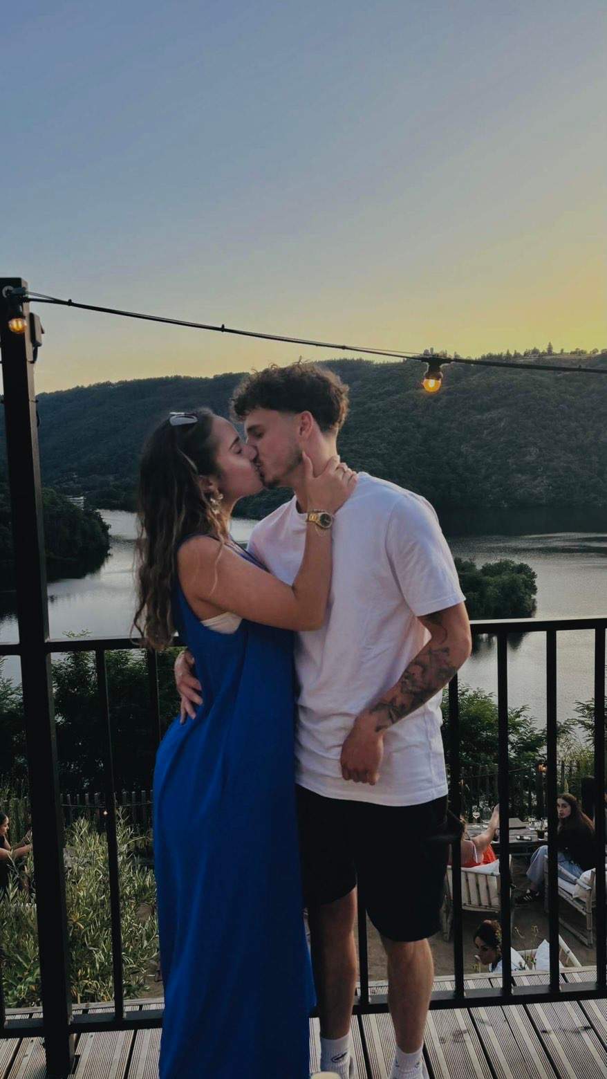 La photo d’origine : un couple qui s’embrasse sur une terrasse, devant un lac.